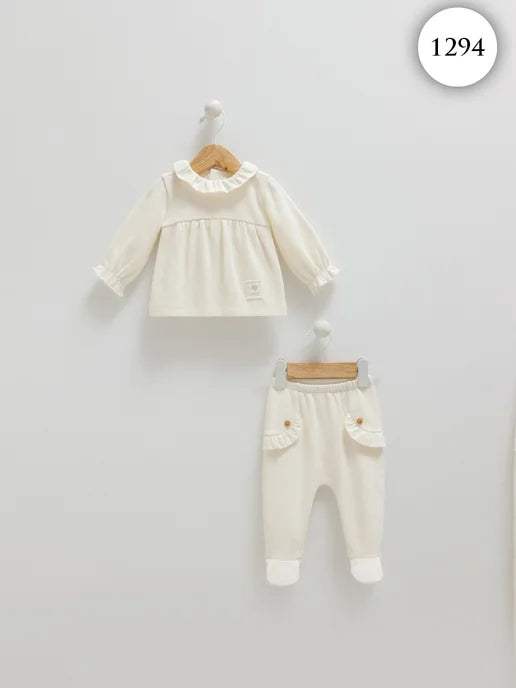 Ensemble bébé Caramell écru sur cintres : haut à volants et pantalon à pieds, vue de face