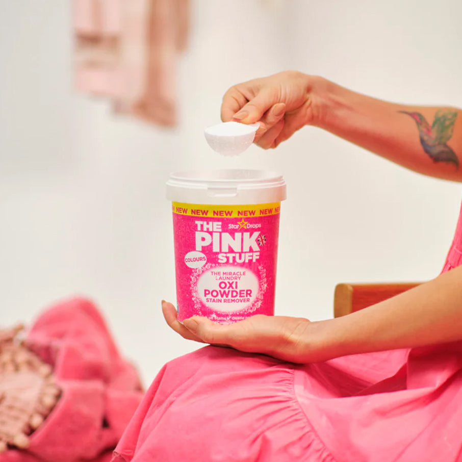 Dosette de poudre Oxi Miracle Couleurs The Pink Stuff tenue au-dessus du pot