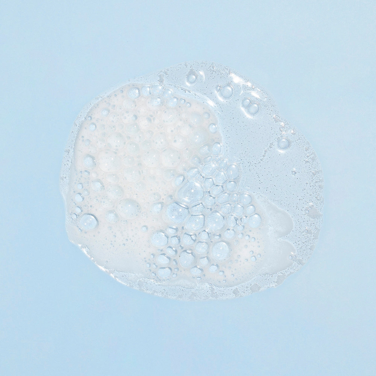 Texture du gel lavant corps et cheveux 2 en 1 Biolane et sa mousse sur fond bleu clair