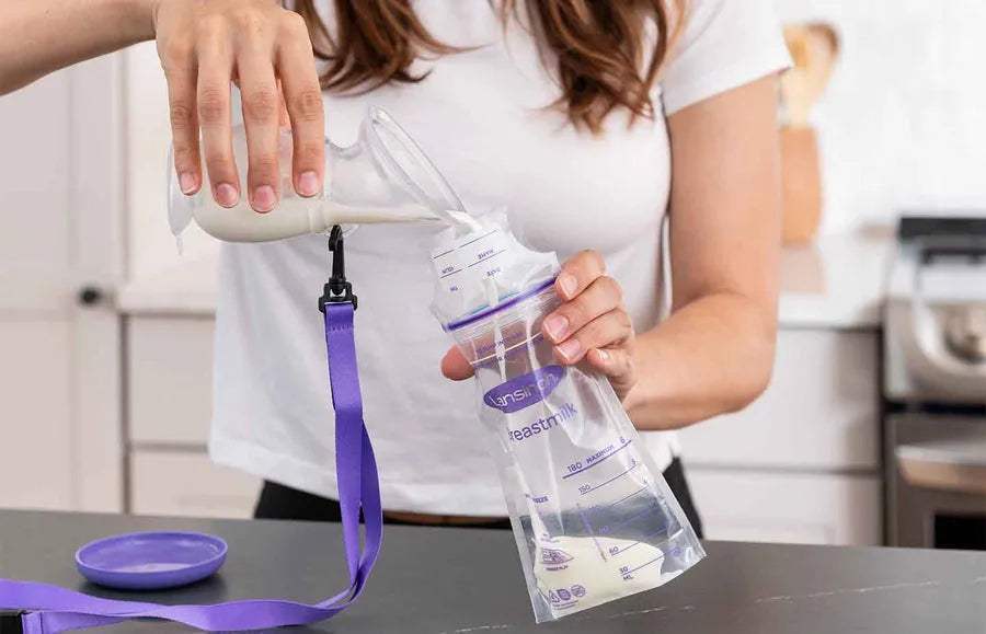Versement du lait tiré d'un biberon dans un sachet de conservation Lansinoh